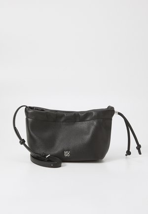 Bolso cruzado de cuero negro con correa ajustable y cierre de cordón, que presenta un pequeño logo metálico "HUGO" en el centro frontal.