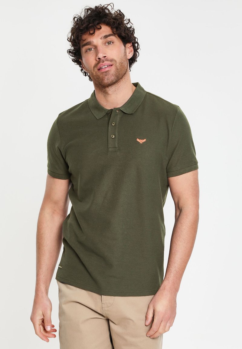 Polo shirt verde scuro con una chiusura a due bottoni, maniche corte e un piccolo logo arancione ricamato sul petto.