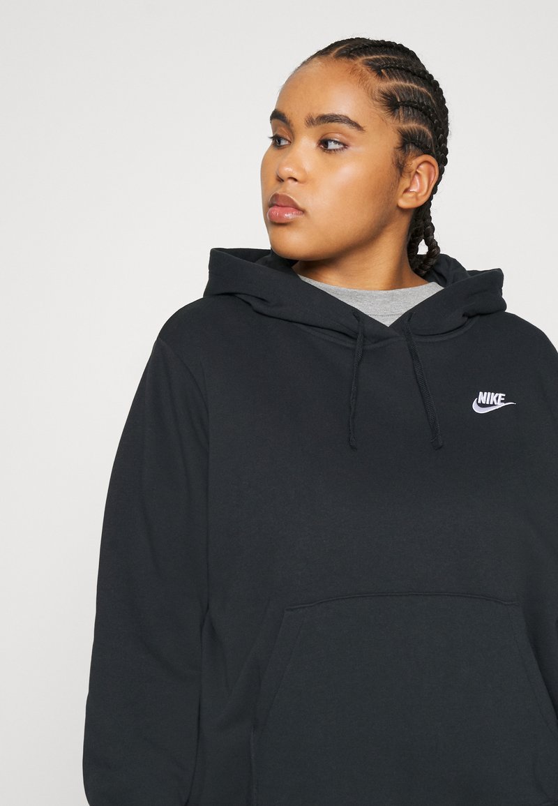 Sudadera de algodón negra con un bolsillo frontal y capucha con cordón. Presenta un logo de Nike blanco en el pecho. Textura suave, corte relajado.