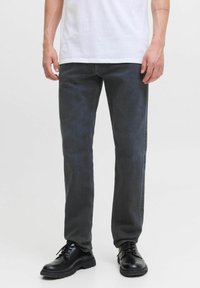 Tummanharmaat suorat denim-farkut, joissa on hieman teksturoitu pinta. Yhdistetty mustiin nauhallisiin kenkiin ja valkoiseen t-paitaan.