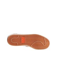 Suola di una sneaker con un motivo a spina di pesce e un logo centrale. Il design presenta un colore chiaro con una superficie di presa texturizzata.