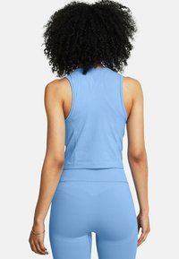 Top sportivo a maniche corte di colore azzurro chiaro con design aderente, taglio senza maniche e texture liscia, abbinato a leggings a vita alta coordinati.