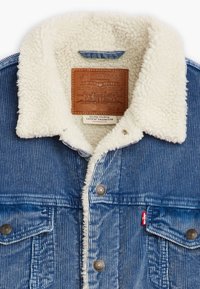 Denim jacket with a shearling collar, blue corduroy texture, and leather label. Features metal snaps and a small red Levi's tag.
