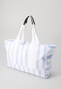Saco de tote feito de tecido riscado em azul claro e branco, com duas alças resistentes com detalhes pretos e um design espaçoso.