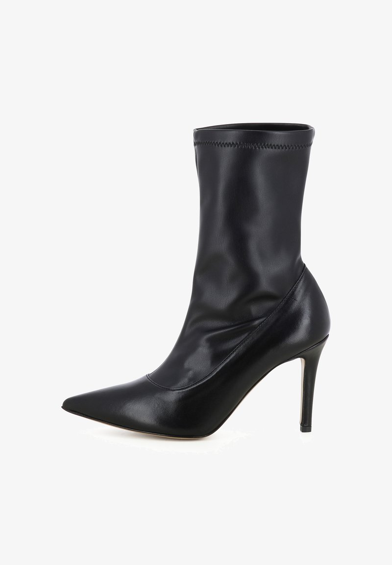 Bottine en cuir noire à bout pointu avec un talon haut élancé et des détails de surpiqûres sur le bord supérieur, présentée en profil droit.