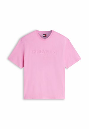T-shirt rose clair à manches courtes et col rond avec le texte "TOMMY JEANS" en relief et petit logo Tommy Hilfiger à l'intérieur du col.