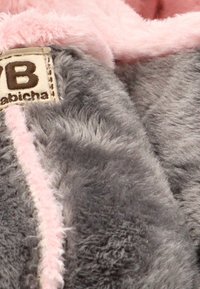 Tejido de felpa gris con costuras y forro en rosa. Presenta una etiqueta con las letras "VB" y el nombre "Habicha". Textura suave y diseño acogedor.
