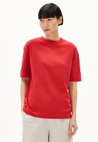 Rode T-shirt met korte mouwen van zachte katoen, met een ronde hals en een klein geborduurd logo op de borst. Glad van structuur.