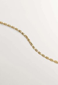 Collar de cadena de metal tono oro que presenta formas ovaladas interconectadas con un acabado suave y textura uniforme, dispuestas planas sobre un fondo claro.