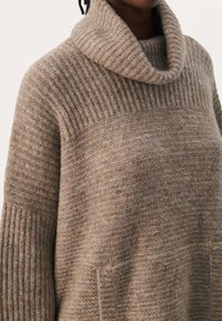 Beanie-Stil-Pullover in Hellbraun, mit geripptem Kragen und strukturiertem Körper. Weiches, kuscheliges Material mit lockerer Passform und Seitentaschen.