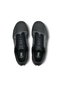 Baskets de sport noires avec tige en mesh, système de laçage et semelles rembourrées. Présente le logo "on", le nom du modèle et des motifs texturés sur les côtés.