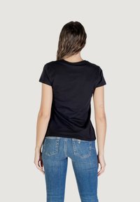 Zwarte katoenen T-shirt met korte mouwen en ronde halslijn, gecombineerd met blauwe denim jeans met achterzakken en een slim fit ontwerp.