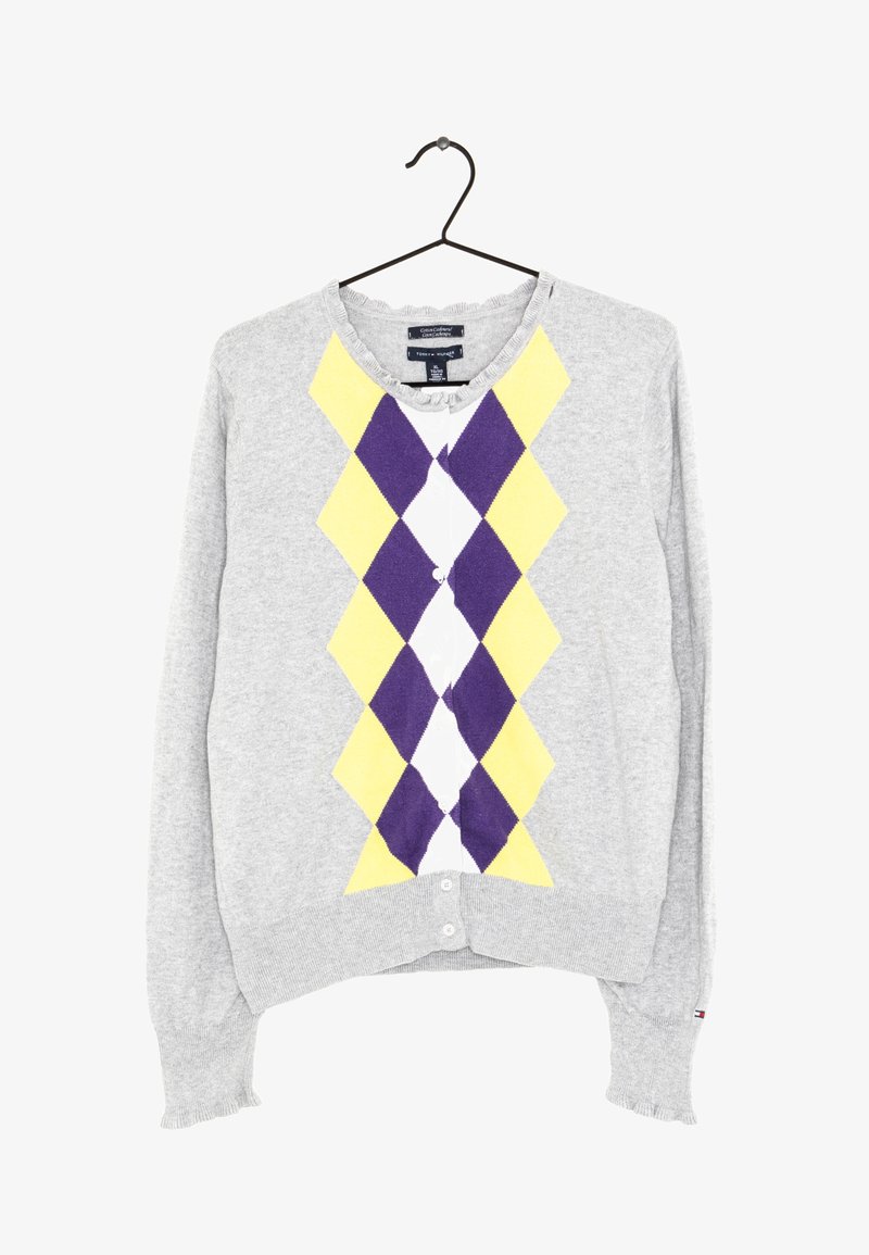 Cardigan gris clair avec motif losanges jaunes et violets sur le devant, boutonné, suspendu sur un cintre noir.