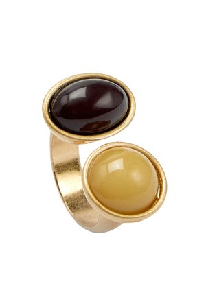 Złoty pierścionek z dwoma dużymi owalnymi kamieniami kaboszonowymi, jednym ciemnoczerwonym i jednym jasnżółtym, osadzonymi obok siebie na otwartej obrączce.