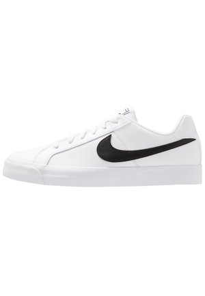 Baskets basses blanches avec logo Nike swoosh noir sur le côté et lacets blancs sur fond blanc.