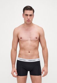 Zwarte boxershorts met een witte tailleband waarop de tekst "Originals Studio" staat. Glad fabric, aansluitend ontwerp en mid-thigh lengte.