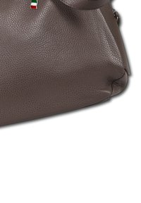 Braune, strukturierte Ledertasche mit einem kleinen, an der oberen Kante angenähten Italienflaggen-Ripsband auf einem weißen Hintergrund.