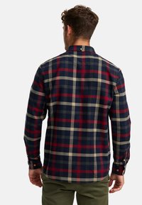 Rood, marineblauw en beige geruit flanellen overhemd, met knopen en een kraag, voorzien van lange mouwen en een afgeronde zoom, gemaakt van zacht textielmateriaal.