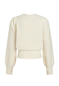 Suéter de punto color crema con un diseño recortado, mangas abullonadas y un dobladillo acanalado con un patrón texturizado.