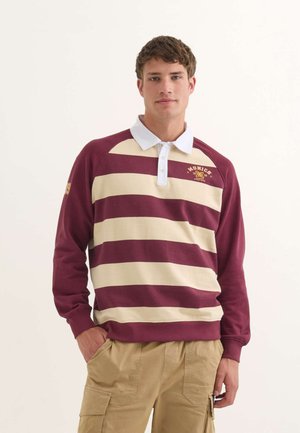 Polo shirt à rayures bordeaux et crème à manches longues avec un col blanc et un logo brodé. Coupe décontractée, poignets côtelés et matériau en coton doux.