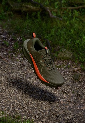 Lightweight running shoe featuring an olive green mesh upper with orange accents, textured surface, and a rugged sole for traction.