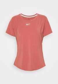 Camiseta roja de Nike de manga corta con un escote redondo, acento de logo blanco en el pecho y una textura suave y lisa.