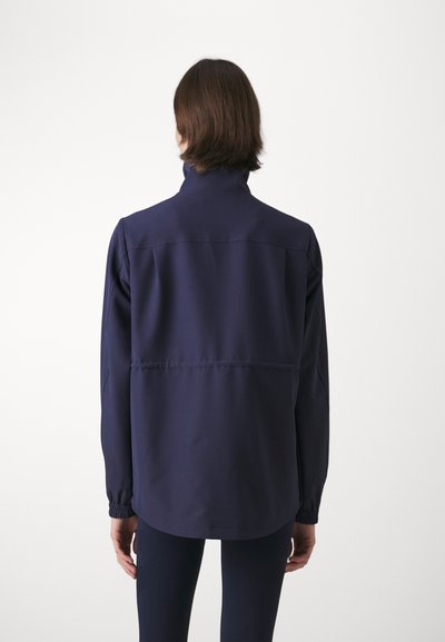 Navy blue jacket with a high collar, elastic cuffs, and a straight hem. Made from smooth fabric, featuring a subtle stitch across the back.