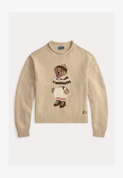 Bež pleteni pulover s medvjedom koji nosi prugasti pulover, bijele hlače i smeđe čizme. Rebrasti rukavi i donji rub; vezene inicijali "R.L."