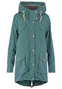 Turkusowy płaszcz przeciwdeszczowy w białe grochy, z kapturem na sznurek, przednimi kieszeniami oraz zapięciami na guziki. Gładka faktura i długość do połowy uda.