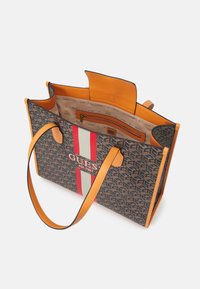 Duża torba na ramię z brązowym wzorem na płótnie, pomarańczowymi skórzanymi akcentami i centralnym czerwono-szarym wzorem w paski. Zawiera wewnętrzną kieszeń na zamek.