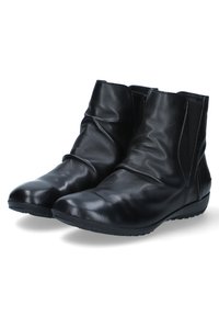 Bottines en cuir noir avec une texture lisse, des panneaux latéraux élastiques et un bout arrondi. La semelle en caoutchouc profil bas offre confort et stabilité.