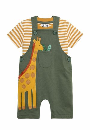 Salopetă verde cu un design de girafă galbenă și o buzună, asortată cu un tricou cu mânecă scurtă în dungi galbene și albe.