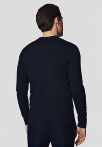 Granatowy sweter z okrągłym dekoltem wykonany z miękkiej dzianiny, z długimi rękawami i ściągaczem u dołu. Widok z tyłu ukazuje dopasowaną sylwetkę.