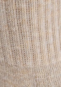 Beżowa włóczkowa skarpetka o pionowym prążkowanym wzorze, gładkiej powierzchni i lekko elastycznym uczuciu, wykonana z miękkiego, oddychającego materiału.