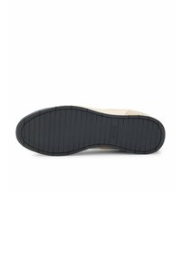 Suola delle scarpe in gomma nera, con scanalature orizzontali per la trazione. Parte superiore in suede beige con una texture liscia.