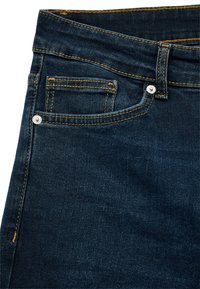 Vaqueros de mezclilla azul oscuro con un diseño clásico, con costuras naranjas, bolsillo frontal y detalles de botón de metal en la cinturilla.
