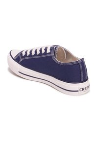 Sneaker in tela navy con lacci bianchi, punta rotonda, suola in gomma bianca e striscia navy a contrasto sulla suola. Nome del marchio sul tallone.