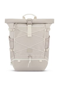Jasnobeżowy plecak z klapą rolowaną, regulowanymi paskami, białymi akcentami, przednim detalem z linką bungee i naszywką z logo. Wytrzymały materiał z bocznymi kieszeniami.