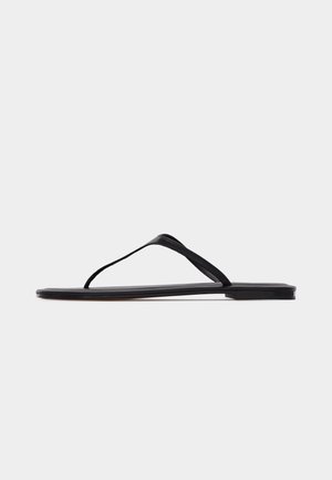 Schwarze flache Flip-Flop-Sandale mit dünnen Riemen und minimalistischem Design, seitlich vor hellem Hintergrund gezeigt.