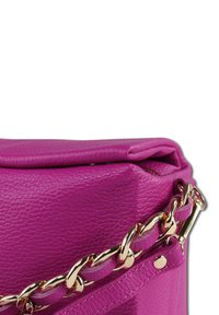 Roze leren tas met een gestructureerde vorm, voorzien van een gouden kettingband en een ritssluiting aan de bovenkant. Details omvatten een logobadge.