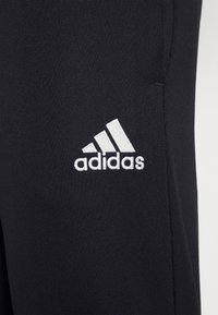Schwarze Sporthosen aus weichem Stoff mit glatter Textur. Verfügt über ein weißes, gesticktes Adidas-Logo auf dem linken Oberschenkel.