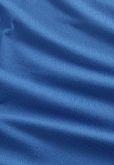 Niebieska tkanina o gładkiej teksturze, z ukośnymi żłobionymi wzorami, wykazująca lekkie drapowanie i ruch.