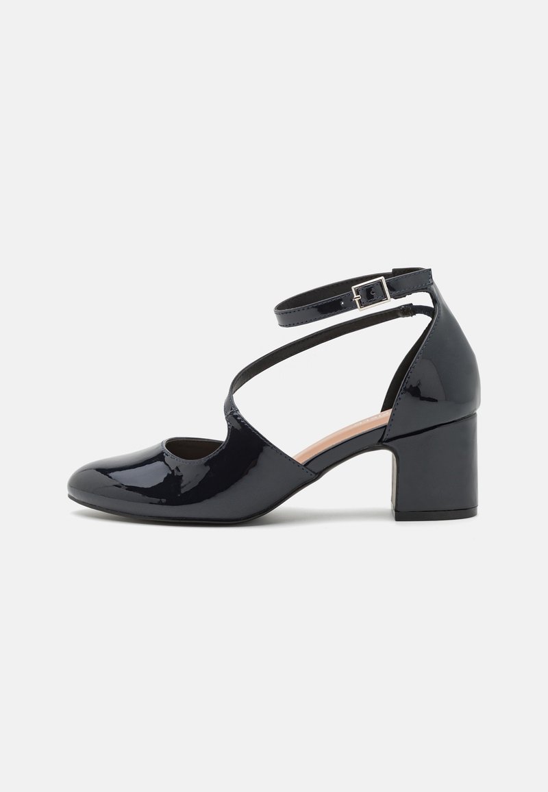 Chaussure à talon en cuir verni noir avec design à bout ouvert, bride à la cheville et talon carré épais. Texture lisse et finition brillante.