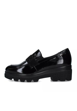 Scarpa in vernice nera con ampio cinturino in velcro, dettaglio testurizzato e suola robusta. Punta arrotondata con un leggero tacco.