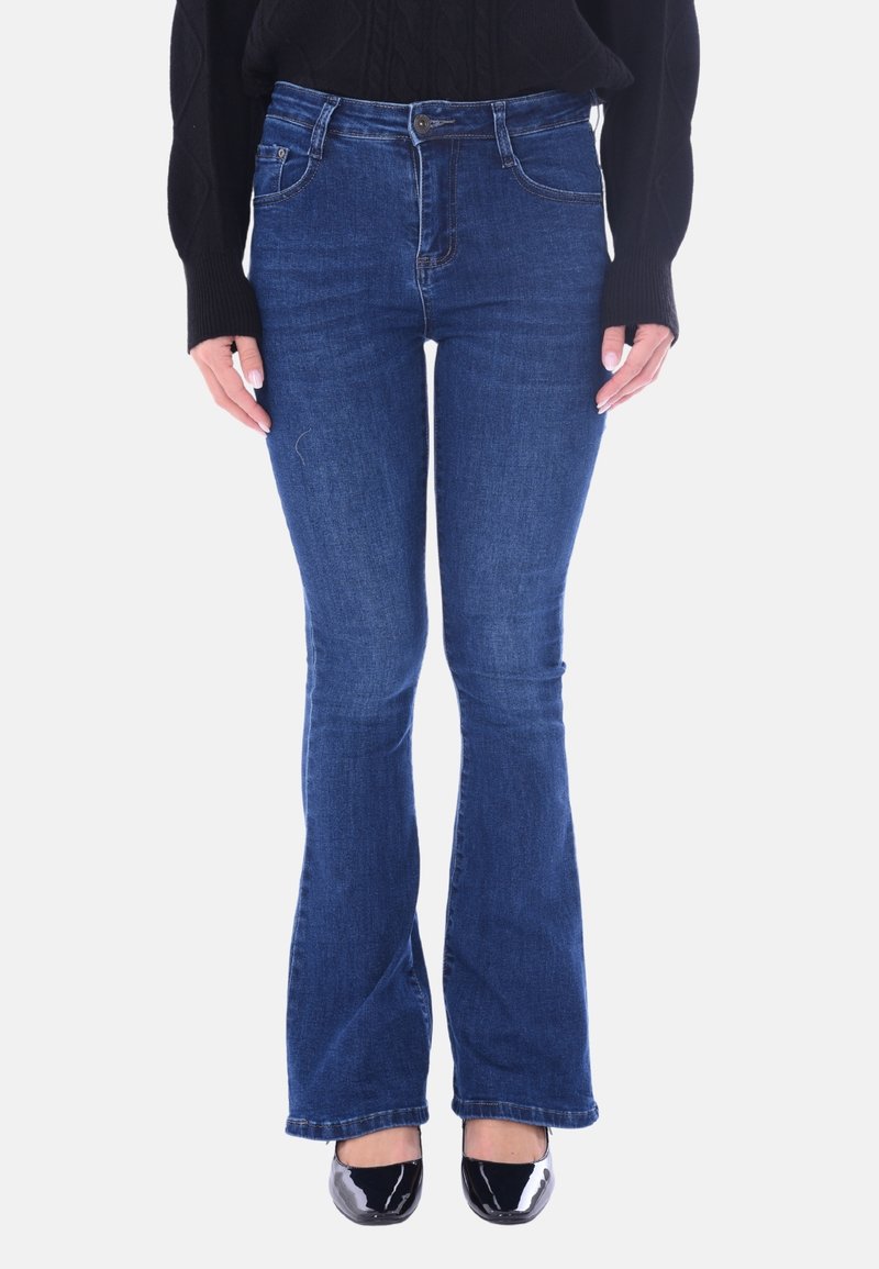 Jeans flare in denim blu con vita media, dettagli cuciti e design classico a cinque tasche; abbinati a scarpe in vernice nera.