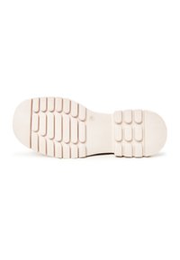Semelle de chaussure blanche avec des reliefs rectangulaires en rangées pour la traction, affichée sur un fond blanc uni.