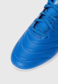 Scarpa da calcio blu con superficie testurizzata, perforazioni, linee di design lisce e sistema di allacciatura tradizionale. Realizzata in materiali sintetici.