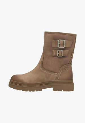 Brown leather ankle boot with two metal buckles, rubber outsole, round toe, contrasting stitching, and slight heel elevation.