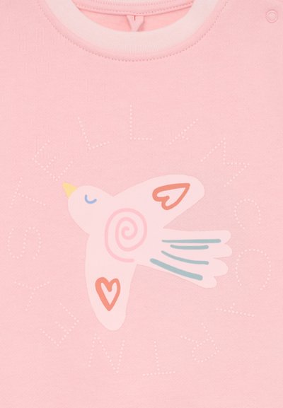 Sudadera rosa claro con un gráfico estilizado de un ave con un diseño en espiral y acentos en forma de corazón, junto al texto "STELLAMCC." Material de algodón suave.