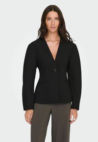 Černé sako s V výstřihem, jednobodovým zapínáním, strukturovanými rameny a dvěma předními kapsami. Hladká látka s ostrými švy.